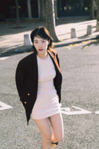 自然光が差し込む石畳の街を散歩する女性