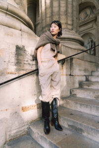 自然光が差し込む石畳の街を散歩する女性