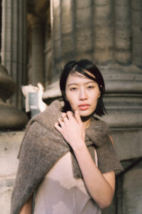 自然光が差し込む石畳の街を散歩する女性