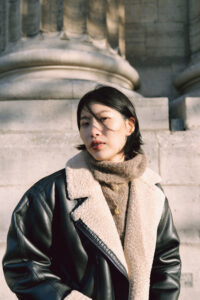 マニッシュコートと秋香る街を歩く女性の写真