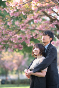 桜を背景にハグをするカップル