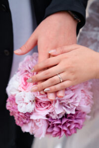 結婚指輪と淡いピンクのブーケ