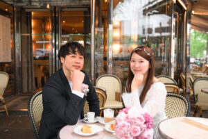 冬のパリ カフェのテラス席で微笑むカップル