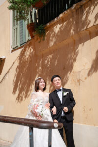 南仏のパステルの壁の前で寄り添うカップル