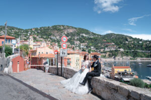 ヴィルフランシュ＝シュル＝メールの景色を前に談笑するカップル