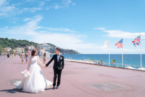 ニースの海岸沿いを手をつないで歩くカップル