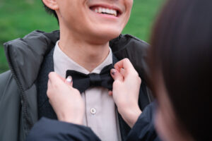 新婦が新郎の蝶ネクタイを直す手元