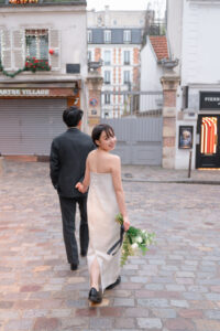 石畳の道を歩いているカップル こちらを見ている新婦