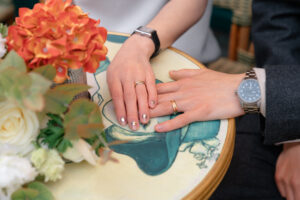 カフェのテーブルの上で手を重ねるカップル