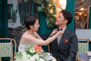 パリのカフェ 互いの身だしなみを整えるカップル