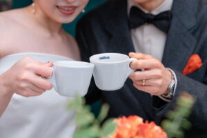 コーヒーカップで乾杯をするカップル