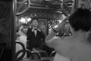 パリのカフェの鏡越しに身だしなみを整えるカップル