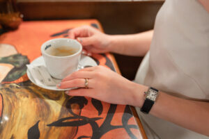 コーヒーカップを押さえる新婦の手 指輪と時計