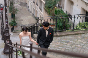 モンマルトルの階段を手をつないで上るカップル