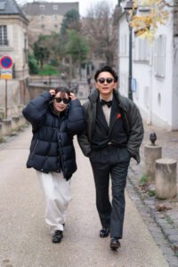 ダウンを着てサングラスをかけながら街を歩くカップル