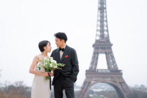 エッフェル塔の前でポーズをするカップル