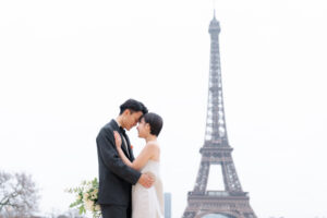 エッフェル塔の前でおでこを付けあうカップル