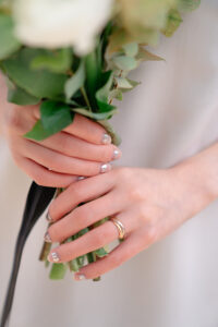 ウェディングブーケを持つ新婦の手と指輪