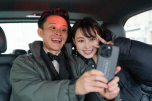 移動の車で自撮りするカップル