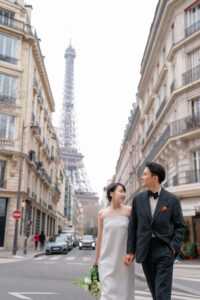 エッフェル塔が見えるおしゃれなパリの街並みをあるくカップル