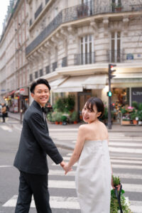 エッフェル塔が見えるおしゃれなパリの街並みで振り向くカップル