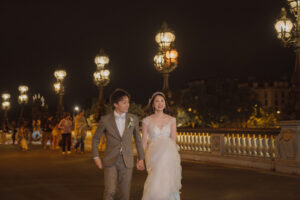パリでのナイトフォトウェディング アレクサンドル三世橋を歩く二人