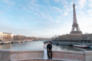 エッフェル塔とセーヌ川を背景に寄り添いあうカップル