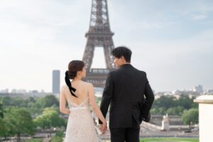 エッフェル塔の前で手をつなぐカップルの後ろ姿