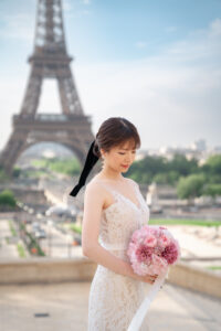 エッフェル塔の前でピンクのブーケをもって微笑む新婦