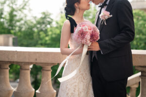 ブーケを手に持ちロマンチックに顔を寄せ合う新郎新婦