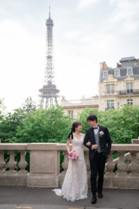 エッフェル塔の前で腕を組んで歩くカップル