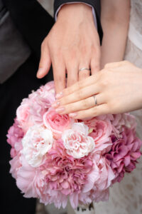 新郎新婦の手元とピンクのブーケ