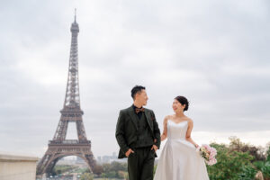 エッフェル塔の前で見つめあいながら歩くカップル