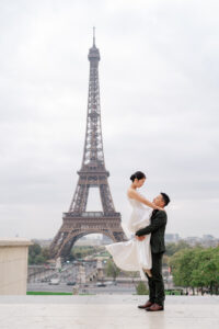 エッフェル塔の前で新婦を抱き上げる新郎
