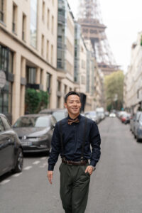 エッフェル塔の見える路地で歩く男性