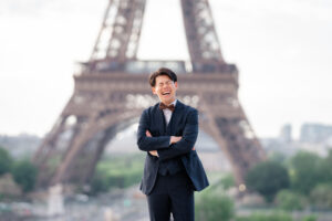 エッフェル塔の前で満面の笑みを浮かべる新郎