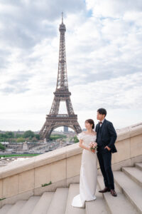 エッフェル塔を背景に遠くを見るカップル