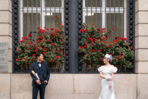 赤い花を背景に見つめあうカップル