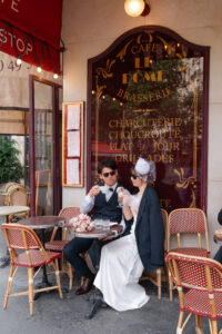 パリのカフェでサングラスをかけるカップル