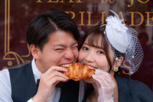 一つのクロワッサンを食べるカップル