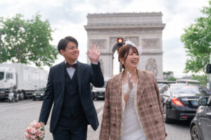 凱旋門を背景に歩くカップル　祝福の声に手を振る