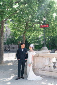 パリ　メトロの看板の前で話をするカップル