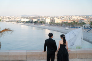高台からニースの海とプロムナード・デ・ザングレの絶景を眺めるカップル