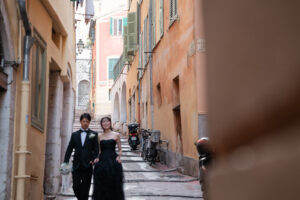 南仏らしいパステルカラーの街並みとそこを歩く新郎新婦