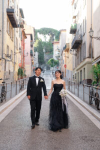 ニース旧市街のカラフルでパステルな街並みを手を繋いで微笑む新郎新婦