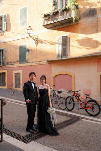 ニースのパステルカラーの壁を背景に佇む新郎新婦