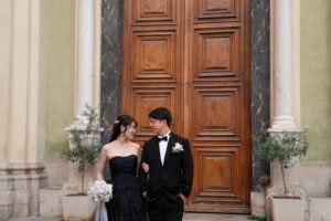 ニースの教会の扉の前で見つめあいながら歩く新郎新婦