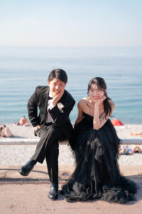 ニースの海を背景に顎に手を置いてポーズする新郎新婦