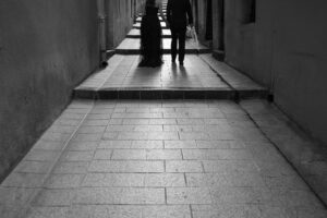 南フランスらしい個性豊かなパステルカラーの街並みを歩く新郎新婦のシックなモノクロ写真